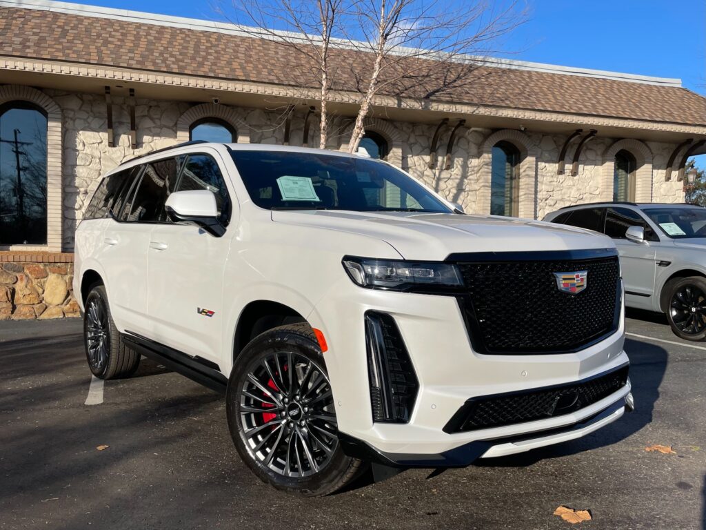 White Cadillac Escalade-V parked in front of AutoPro Nashville car dealership.