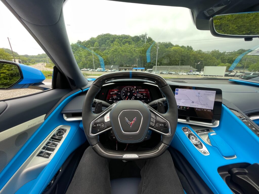 Interior view of a 2023 Chevrolet Corvette Z06 Convertible with vibrant blue accents and advanced digital dashboard.
