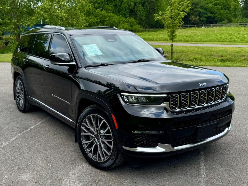 Black 2023 Jeep Grand Cherokee L Summit Reserve exterior front view with chrome trim and stylish alloy wheels.