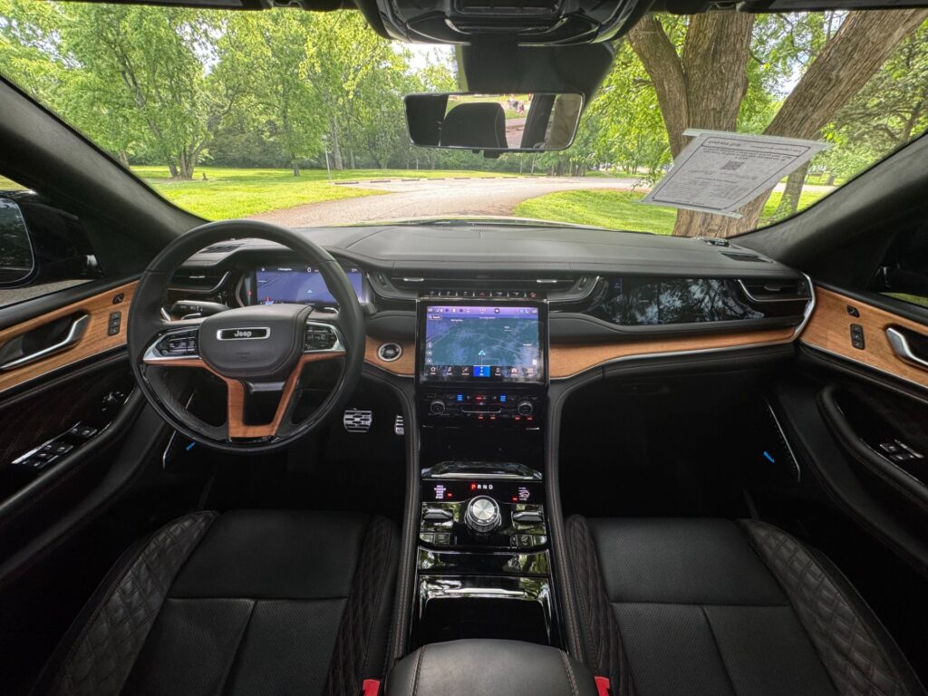 Interior view of the 2023 Jeep Grand Cherokee L Summit Reserve with Advanced ProTech and Luxury Packages – black leather and wood-trimmed cabin.