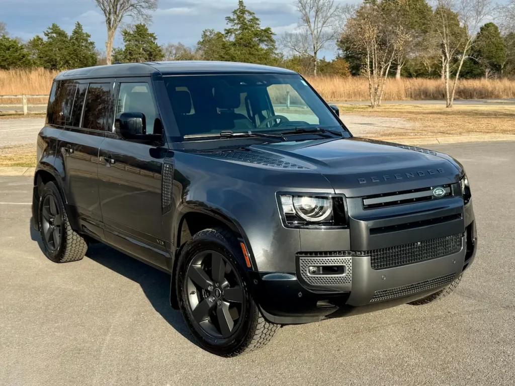 2023 Land Rover Defender 110 V8 in dark gray, front angle with premium black wheels.