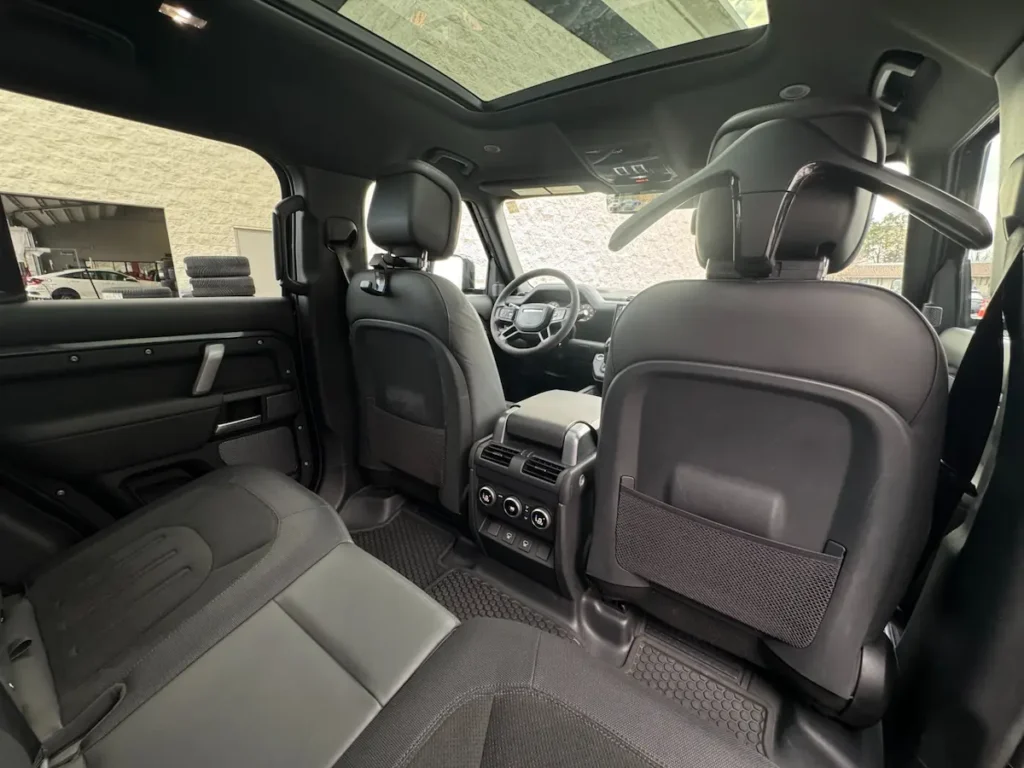 Rear passenger area of a 2023 Land Rover Defender 110 V8 with leather seats.