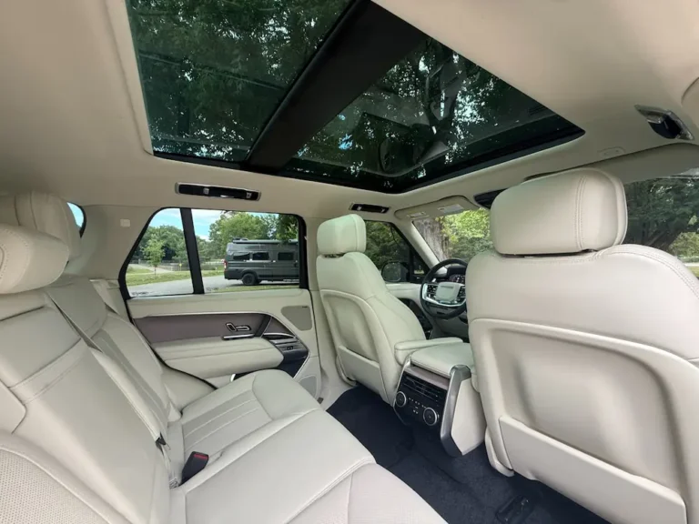 Range Rover SUV rear seating area with white leather seats and panoramic sunroof