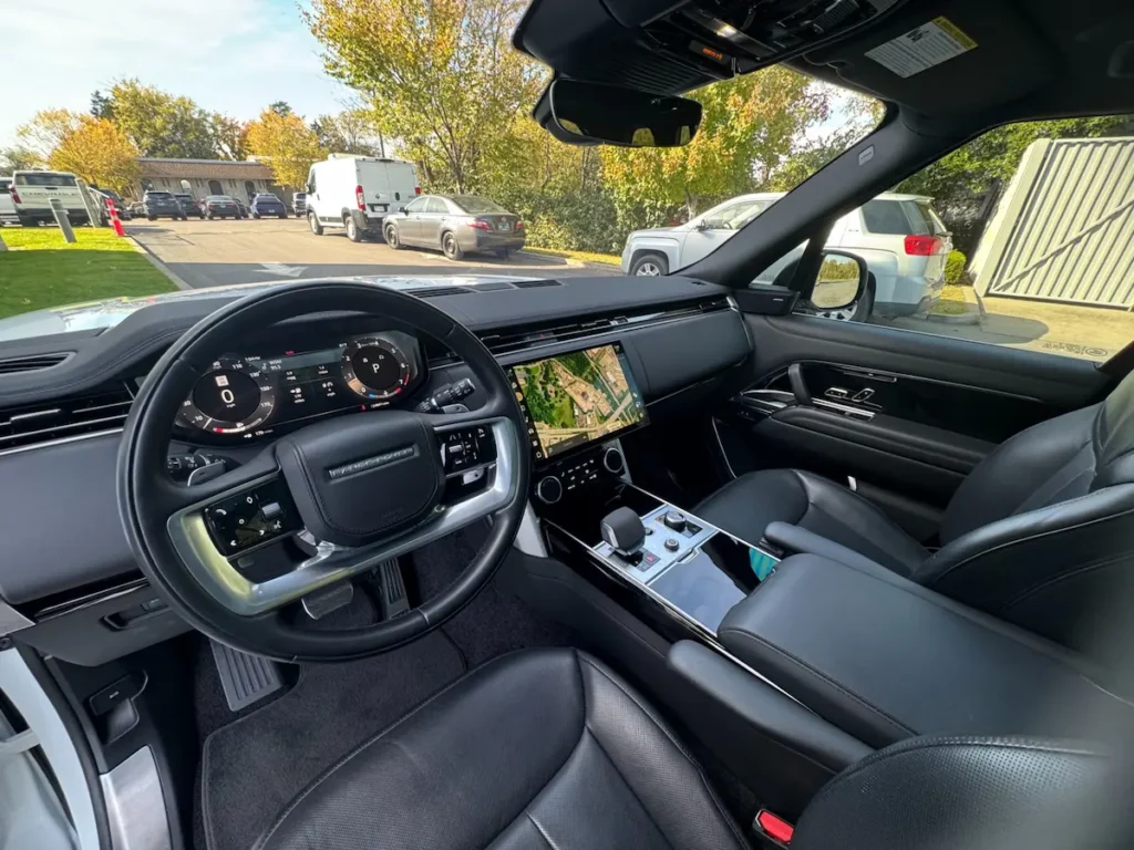 Interior cabin of a 2023 Range Rover P530 SE with digital cockpit and leather seating.