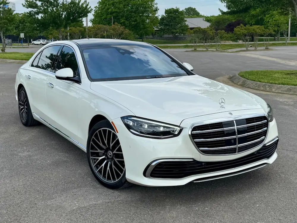 Front angle of 2023 Mercedes-Benz S 580 4MATIC in white featuring chrome grille and LED headlights.