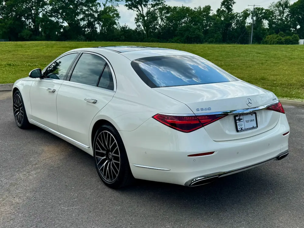 Rear angle of Mercedes-Benz S 580 in white showing aerodynamic lines and chrome trim.