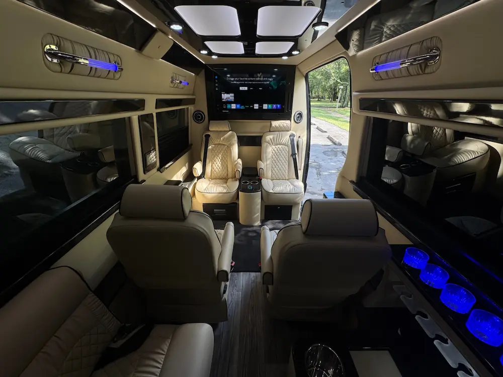 Full luxury cabin of 2023 Mercedes-Benz Sprinter 3500XD Ultimate Limo with LED ambient lighting and entertainment bar.