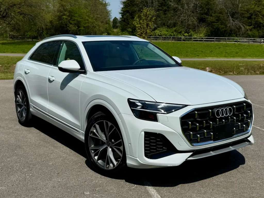 Used 2024 Audi Q8 quattro Prestige 55 TFSI with Black Optic Package parked in sunlight on dealership lot