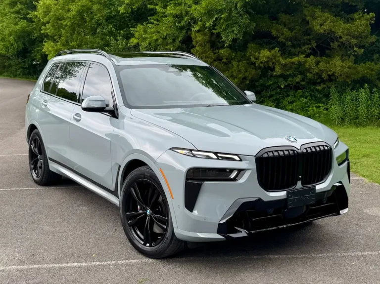 gray BMW X7 three-row SUV with black wheels parked near trees