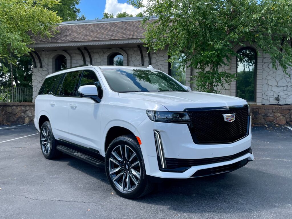 2024 Used Cadillac Escalade SPORT 4WD with DURAMAX DIESEL engine parked in front of a stone building.