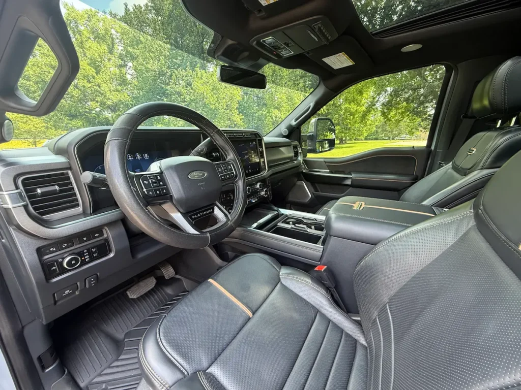 Steering wheel and dashboard of 2024 Ford F-350 Platinum Super Duty with digital cluster and premium finishes.