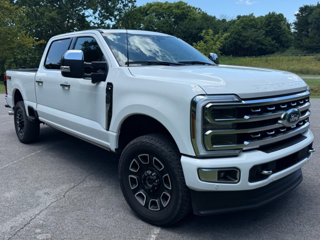 Front angle view of a 2024 Ford F-350 Super Duty Platinum with 6.7L High Output Power Stroke diesel engine in Iconic Silver.
