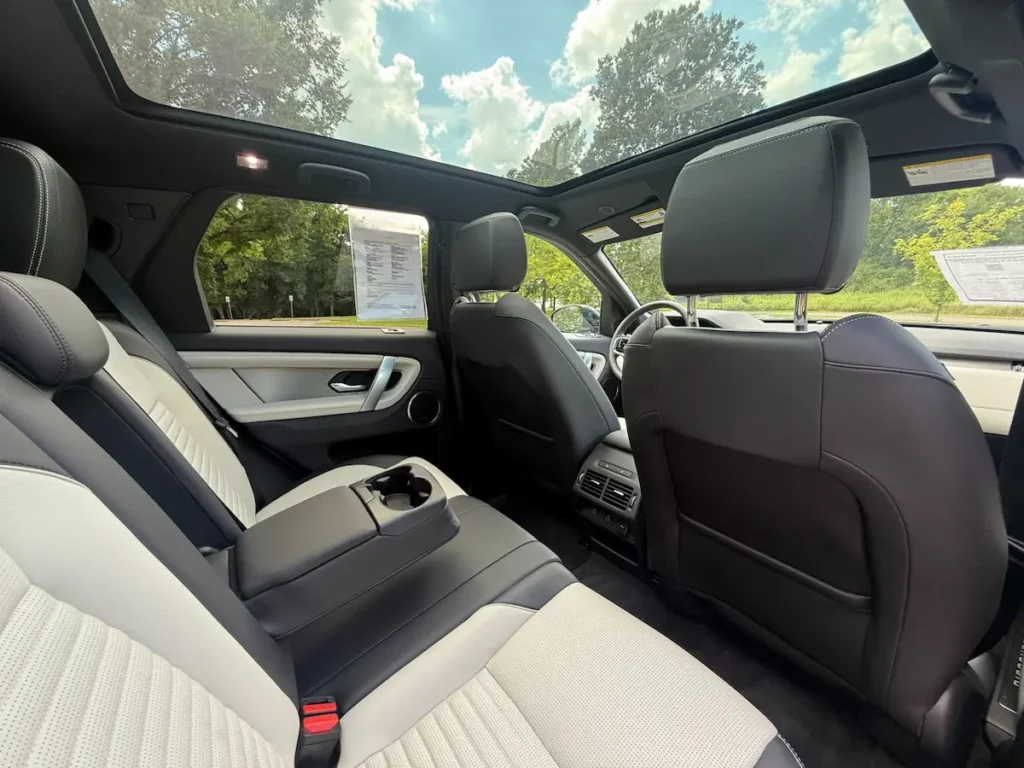 Rear seating and panoramic roof in a 2024 Land Rover Discovery Sport P250 SE.