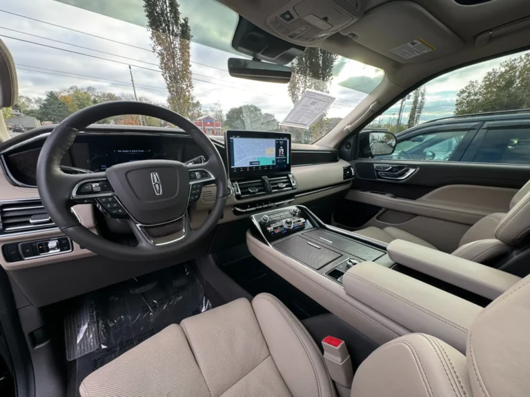 Driver's cockpit view of the 2024 Lincoln Navigator L Reserve, highlighting the digital dashboard, infotainment screen, and steering wheel controls.