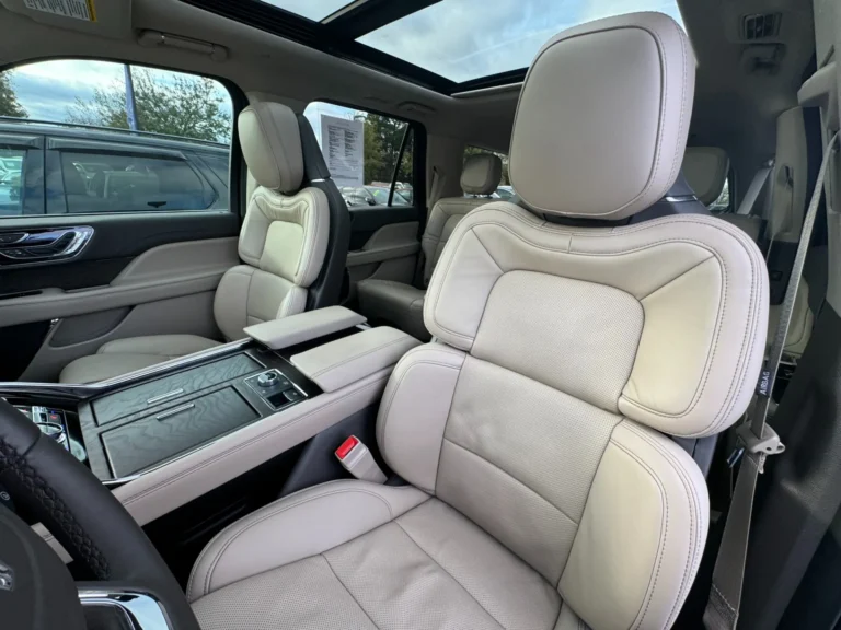 Front passenger seat of the 2024 Lincoln Navigator L Reserve, featuring premium beige leather upholstery and center console design.