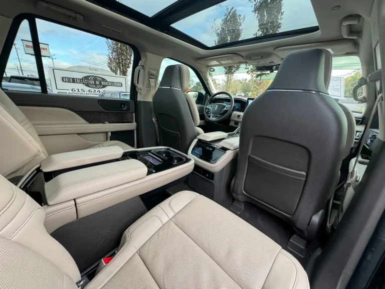 Interior view of a 2024 Lincoln Navigator L Reserve showcasing the rear passenger area with beige leather seats and a panoramic sunroof.
