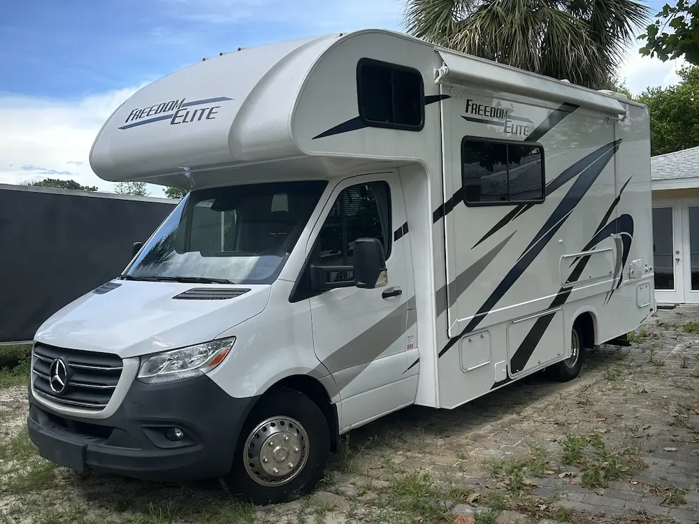 2024 Mercedes-Benz Sprinter 3500XD Freedom Elite Thor RV in white with over-cab sleeping area and side awning.