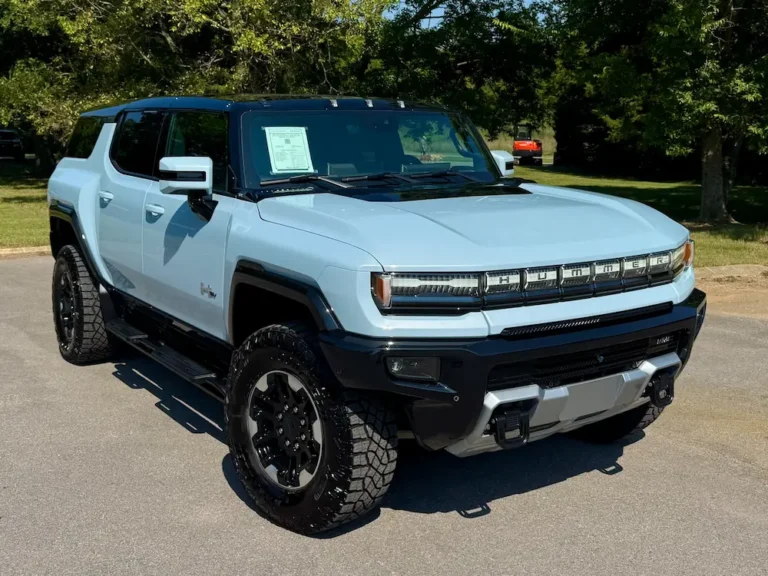 Tide metallic blue 2025 GMC Hummer EV SUV with black accents, photographed from front three-quarter angle.