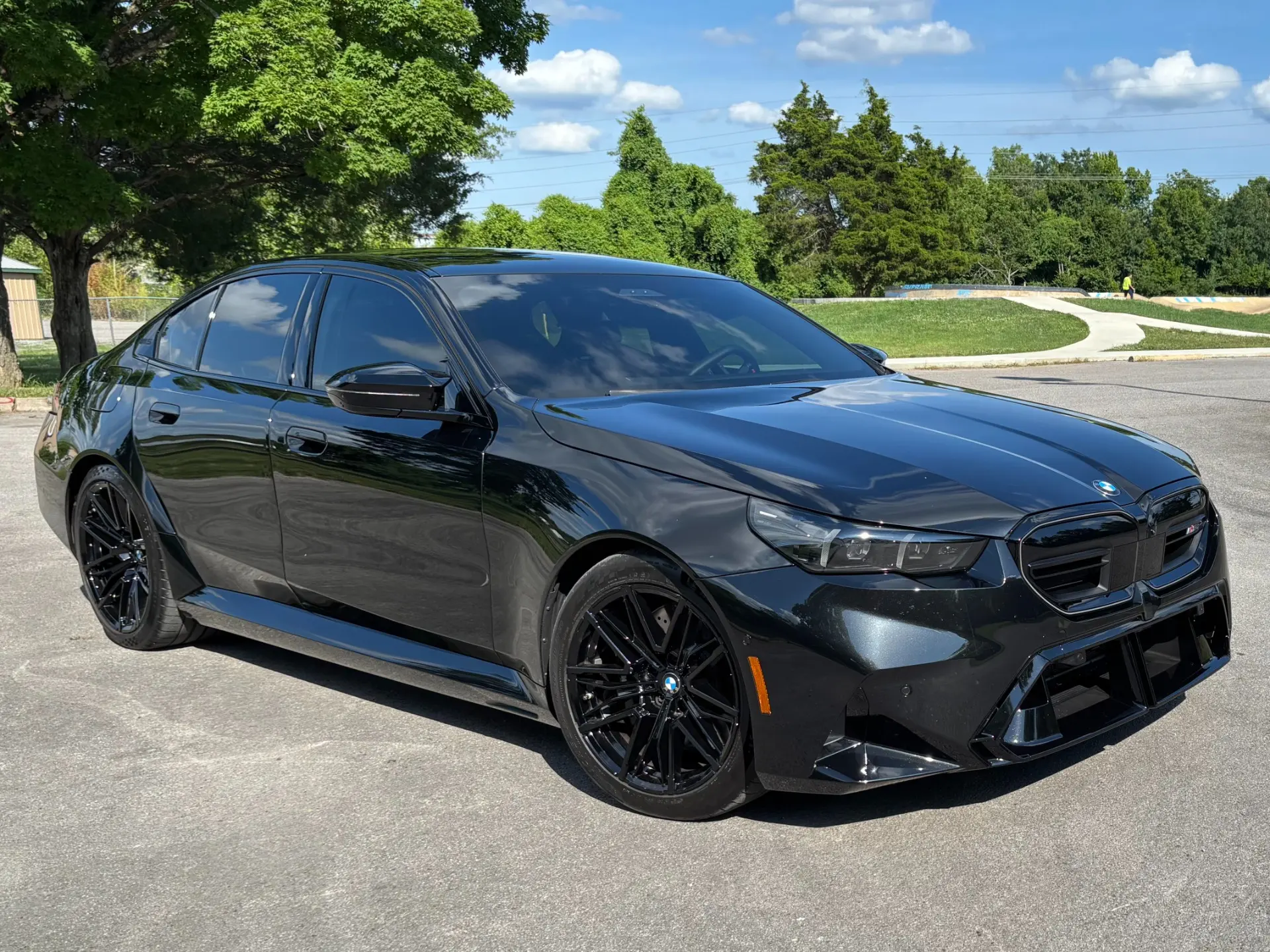 Black 2026 BMW M5 photographed from the front three-quarter angle.