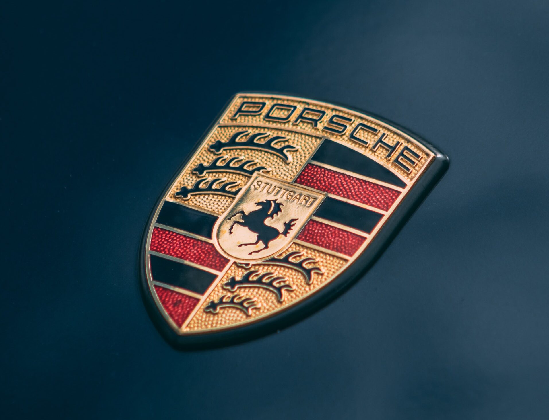 A close-up of a Porsche emblem on a blue background