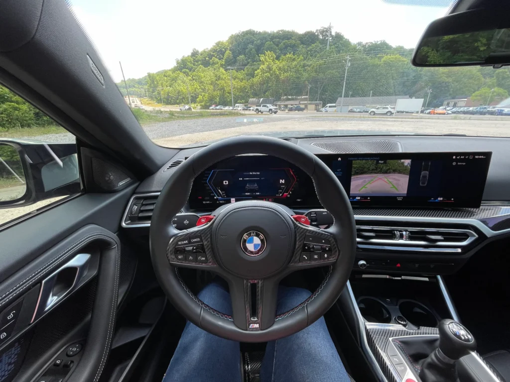 The interior of the 2024 BMW M2 featuring a modern dashboard, digital displays, and premium materials.