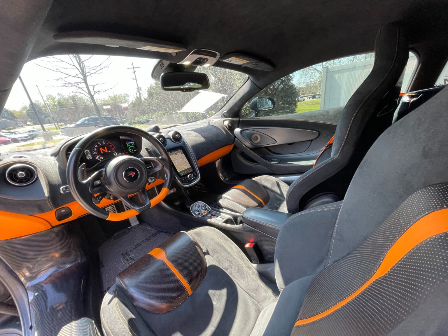 Interior view of a used 2016 McLaren 570S featuring luxury pack and carbon fiber accents.